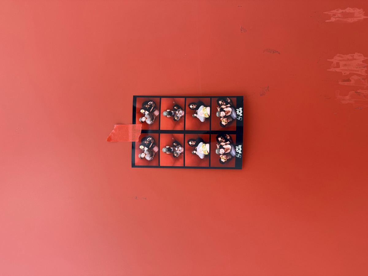 Photobooth strip taped to a red wall